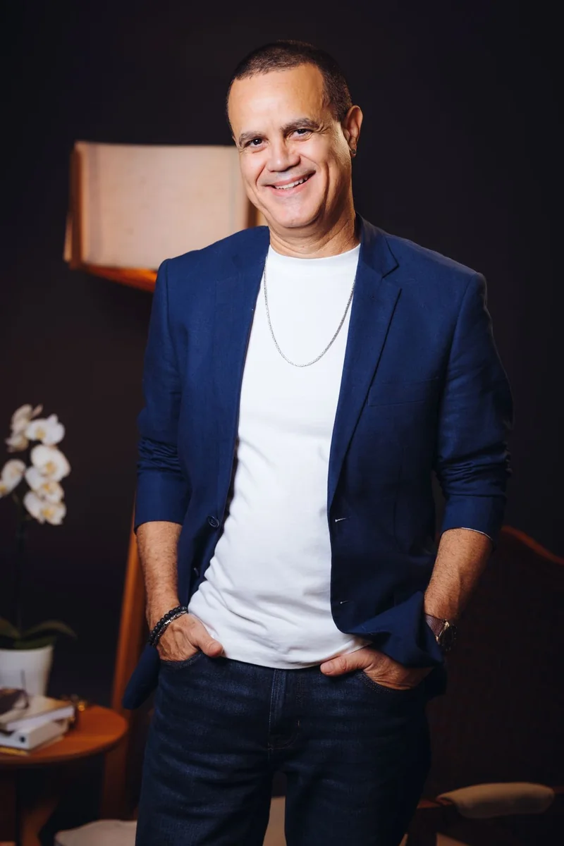Luis Fernando Velasco em pé no consultório, sorrindo
