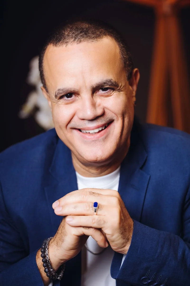 Retrato de Luis Fernando Velasco sorrindo, com as mãos unidas